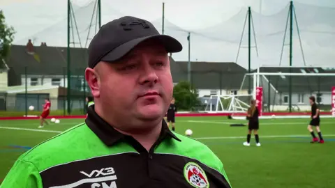 Steven in a black baseball hat a dn Gwent Girls crested football top