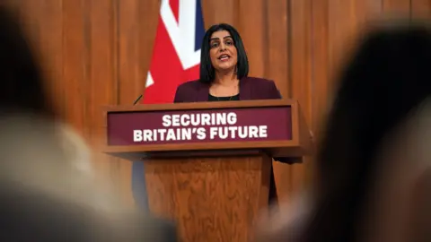 PA Media Lord Chancellor and Justice Secretary Shabana Mahmood wears a maroon blazer and stands behind a podium in Downing Street 