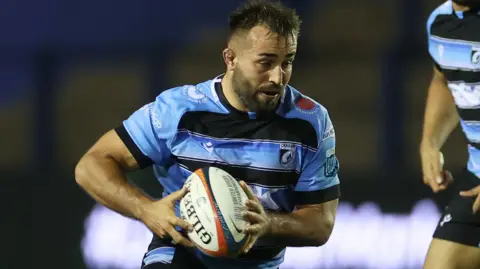 Liam Belcher, with the ball in his hands, playing for Cardiff