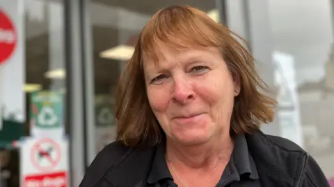 Lady smiling in front of Spar Shop 