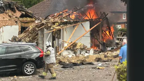 Contributed The remains of a building are on fire on a residential street.