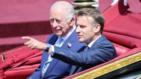 King Charles III and French President Emmanuel Macron talk during a carriage procession to Windsor Castle. Photo: 8 July 2025