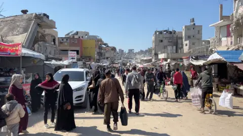 Palestinians walk through a street market in Khan Younis, southern Gaza