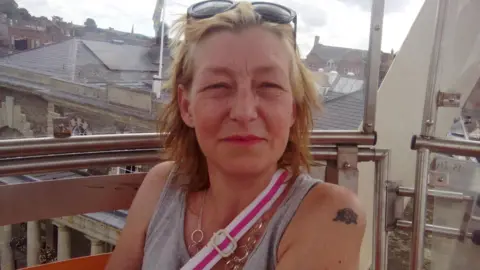 Facebook Dawn Sturgess looking astatine  the camera. She has blonde hairsbreadth  and is wearing a grey vest top. She has sunglasses connected  her caput  and the strap of a container  implicit    her enarthrosis  is disposable   and is wearing a necklace.