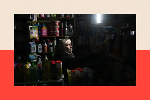 AFP via Getty Images A resident in a shop during a partial blackout 