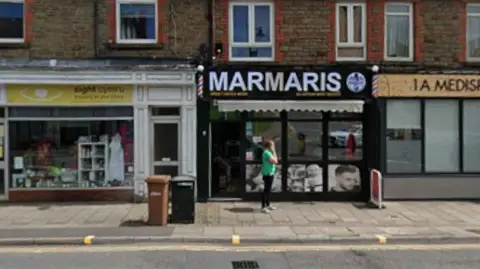 Shop front of high street and Marmaris shop window with black sign and white letters.