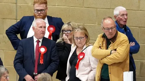 PA Media Labour party activists look on as ballot papers are counted for the 2026 Essex County Council election at Clacton Leisure Centre in Essex