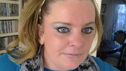 Supplied Jodey Whiting is looking towards the camera. She has blonde shoulder-length hair with a silver hairband and is wearing a a silver coloured scarf and a light blue jumper
