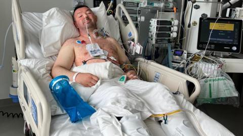 Image of Mark Butcher in a hospital bed