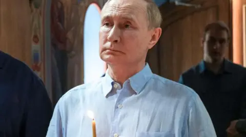 Russian President Vladimir Putin holds a candle during a service at the Valaam Monastery in north-western Russia. Photo: 1 August 2025