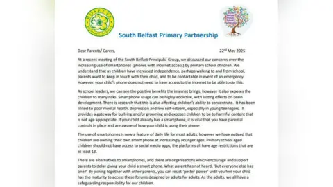 Rosetta Primary School An image of the letter posted by schools to pupils. It reads:
Dear Parents/ Carers, 22nd May 2025
At a recent meeting of the South Belfast Principals’ Group, we discussed our concerns over the
increasing use of smartphones (phones with internet access) by primary school children. We
understand that as children have increased independence, perhaps walking to and from school,
parents want to keep in touch with their child, and to be contactable in event of an emergency.
However, your child’s phone does not need to have access to the internet to be able to do this.
As school leaders, we can see the positive benefits the internet brings, however it also exposes the
children to many risks. Smartphone usage can be highly addictive, with lasting effects on brain
development. There is research that this is also affecting children’s ability to concentrate. It has been
linked to poor mental health, depression and low self-esteem, especially in young teenagers. It
provides a gateway for bullying and/or grooming and exposes children to be to harmful content that
is not age appropriate. If your child already has a smartphone, it is vital that you have parental
controls in place and are aware of how your child is using their phone.
The use of smartphones is now a feature of daily life for most adults; however we have noticed that
children are owning their own smart phone at increasingly younger ages. Primary school aged
children should not have access to social media apps, the platforms all have age restrictions that are
at least 13.
There are alternatives to smartphones, and there are organisations which encourage and support
parents to delay giving your child a smart phone. What parent has not heard, ‘But everyone else has
one?’ By joining together with other parents, you can resist ‘pester power’ until you feel your child
has the maturity to access these forums designed by adults for adults. As the adults, we all have a
safeguarding responsibility for our children.