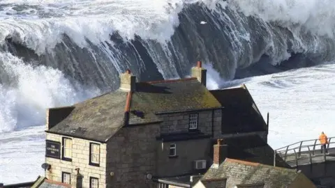 Richard Broome Cove House Inn in Chiswell with a giant wave behind