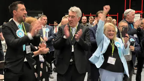 Reform candidates celebrate a victory in Coventry by clapping and punching the air. 