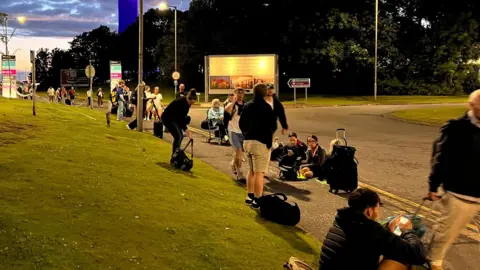 Stranded travellers waiting outside the airport