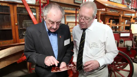royaltrain.co.uk Two men smarty dressed are looking at a photograph together