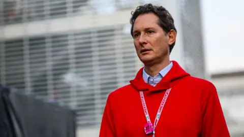 Getty Images Stellantis chair John Elkann, wearing red hoodie over a light blue shirt with racing lanyard around his neck