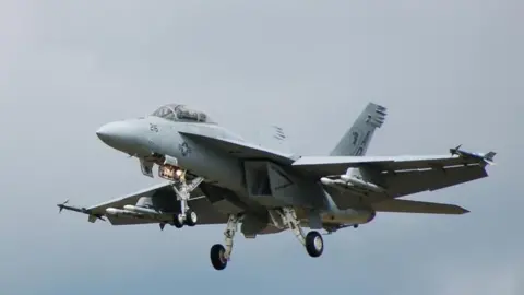 BBC A US Navy Boeing F/A-18 Hornet fighter jet comes in to land