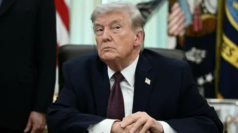 US President Donald Trump takes a question from a reporter in the Oval Office