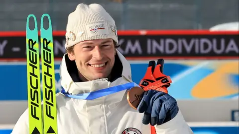 Bronze medalist Sturla Holm Laegreid of Norway smiles holding his bronze medal.