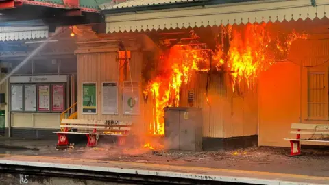 Bright orange flames rip through part of Paignton Station. 