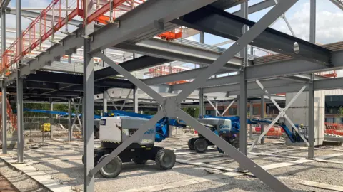 Work on the new history centre in Crewe. There is steel frame with cherry pickers inside the frame