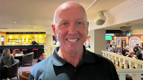 Oliver Conopo/BBC Ray Hales smiling at Barratts club