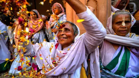 Getty Images Indian Widows throw colorful powders and flower petals at each other as they dance during a celebration of Holi or 'festival of colors' at Gopinath Temple in Vrindavan.