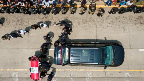 Getty Images Luchtbeelden tonen hoe de kist van Fujimori, gehuld in de Peruaanse nationale vlag, uit een lijkwagen wordt verwijderd