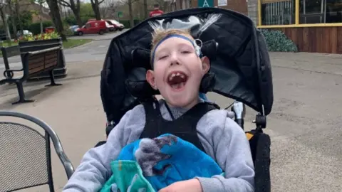 Children’s Hospice South West Riley in a chair with a blanket