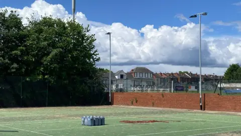 CHRIS SKELTON Work on tennis courts underway, resurfacing work can be seen, and floodlighting is in place in the background.