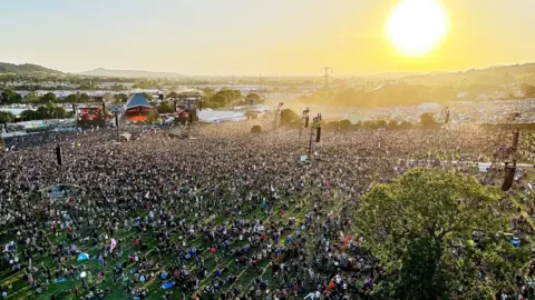 Adam Gohil Aerial view of the Pyramid Stage with the sunset