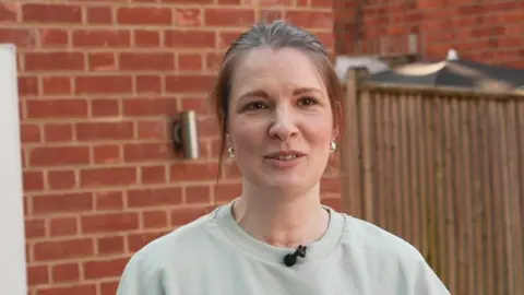 Leanne pictured against a brick wall