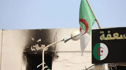 Fire damage to the ophanage building. The building name and the national flag are visible.