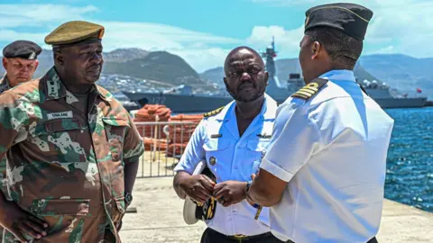SA National Defence Force South African army and naval officers pictured in Simon's Town harbour with ships behind them