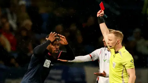 Daniel Phillips is shown a red card by referee Thomas Parsons at University of Bolton Stadium 