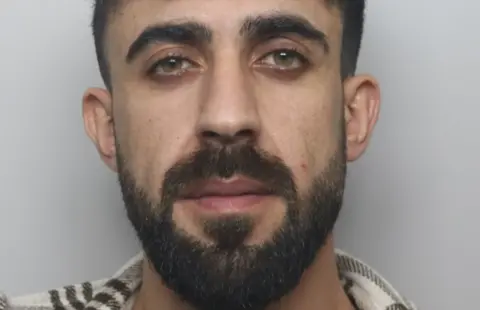 Staffordshire Police A man with dark hair and a beard is looking at the camera.