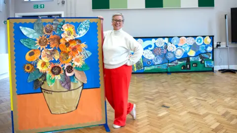 Elmfield School for Deaf Children Head teacher standing with pupil art.