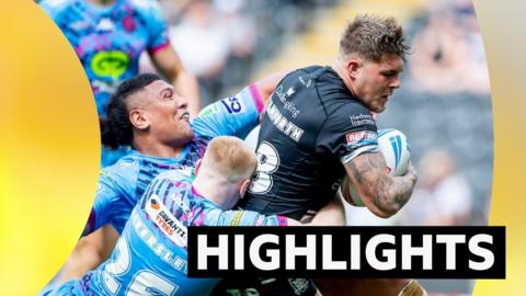 Hull FC player gets pulled back by two Wigan players in a tackle