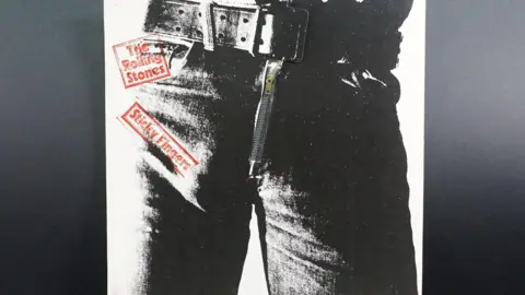 Photo of Rolling Stones album cover. It's a black and white photo of a person's trousers and a thick belt. The album title is in red text.