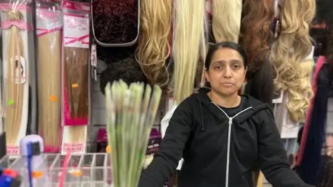 A woman stood in front of a display of wigs