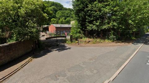 The locked gates of the former Aga foundry in Ironbridge. In the background, the buildings are surrounded by metal fences