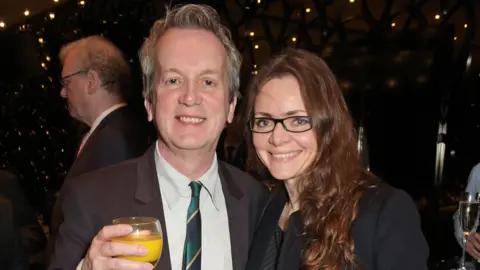 Frank Skinner and Cath Mason at an event in smart clothes