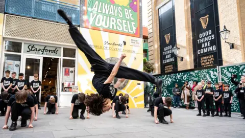 Jayne Jackson The dancers in action outside in Covent Garden, London. One dancer doing a backflip.