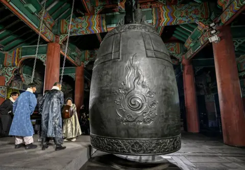 Jung Yeon-je/AFP Os participantes tocaram um enorme sino para dar as boas-vindas ao Dia de Ano Novo de 2025, durante as celebrações após a meia-noite no pavilhão Bosingak, no centro de Seul, em 1º de janeiro de 2025. 