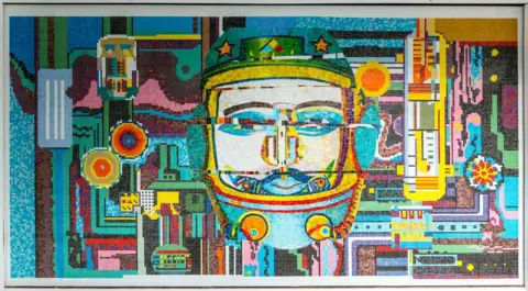 Arts in Redditch A close-up of one of the mosaic panels which makes a face and many different symbols. 