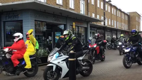 Westbury Court Care & Nursing Home Bikers drive through a high street with helmets on. Two people are dressed as Teletubbies.