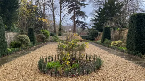 John Wimperis The same garden photographed from the opposite side, with tall trees at the back of the entrance.