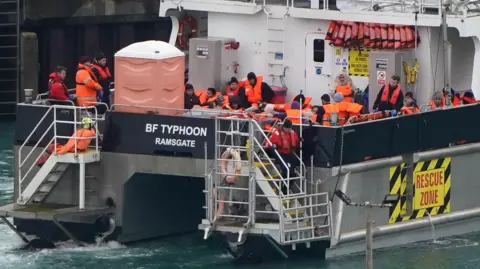Gareth Fuller/PA Media A group of people in life jackets on a boat 
