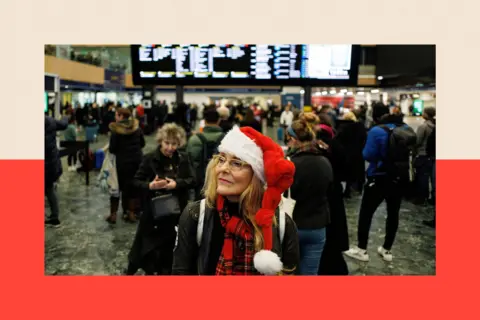 Shutterstock A commuter in a Christmas hat waits for a train