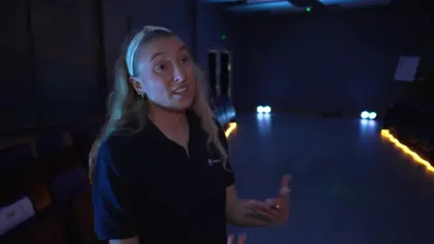 Elise Robinson has long blonde hair and is wearing a blue t-shirt, whilst standing in the new centre.
